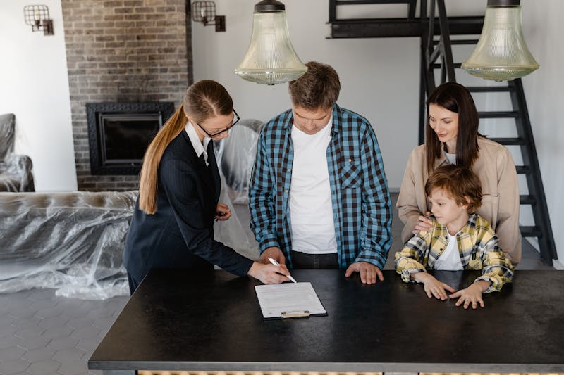A family reviewing paperwork at a kitchen table